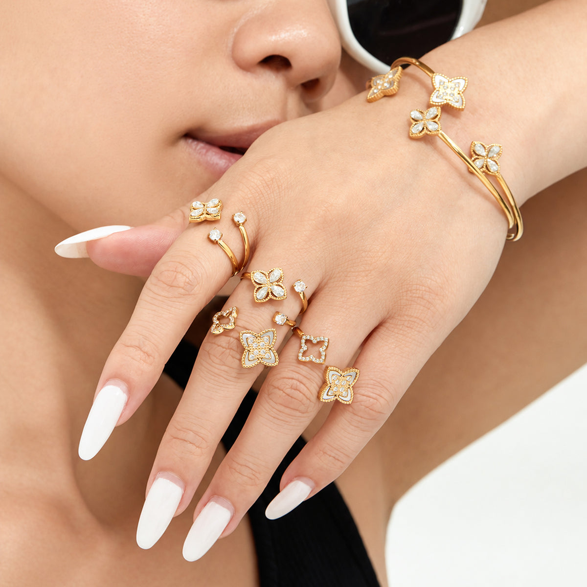Gold-tone flower rings and bangles styled together on the hands and wrist