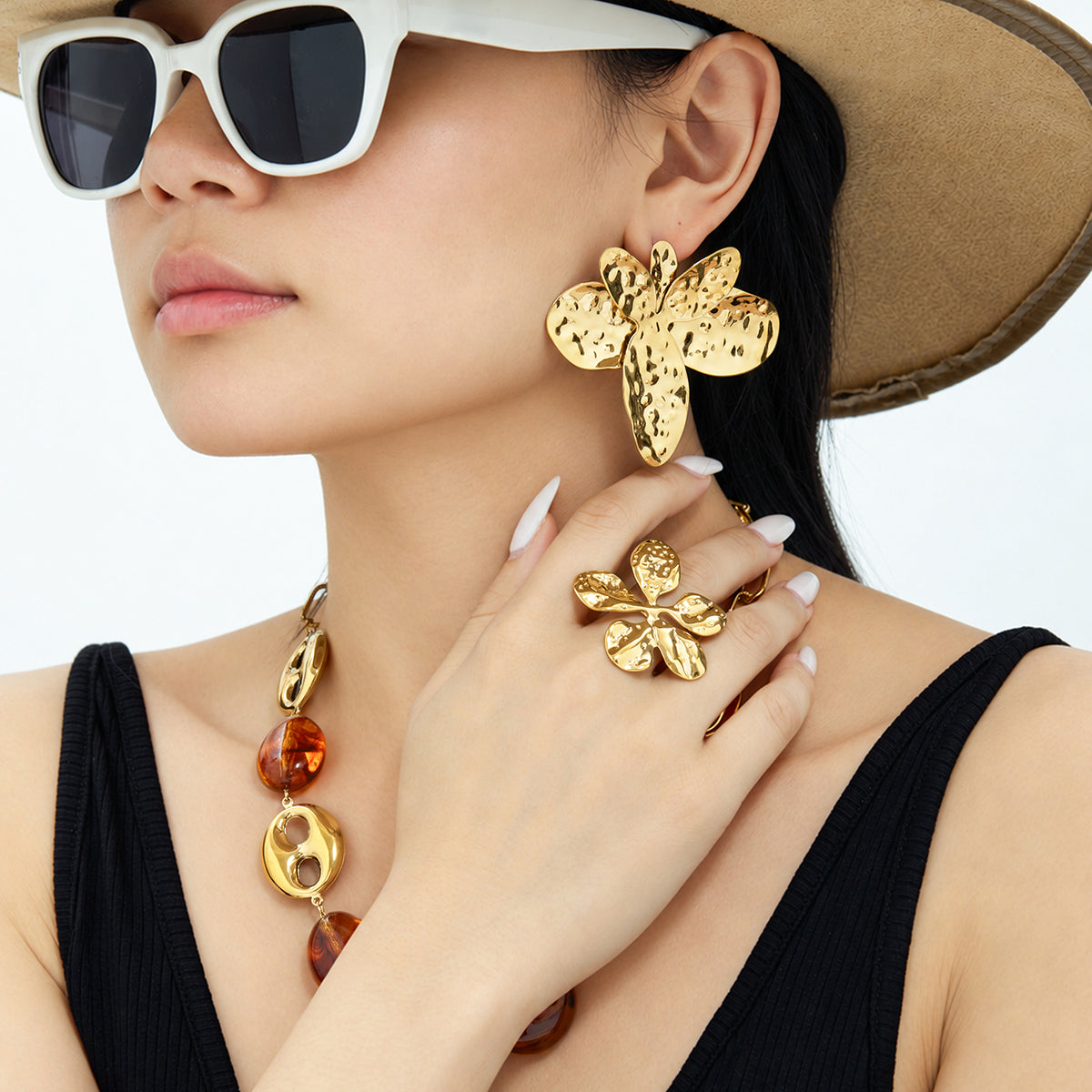 Gold flower statement earrings with hammered floral design worn by model