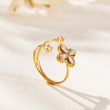 Close-up of a gold-tone open ring with a four-petal zircon flower and clear stone accents