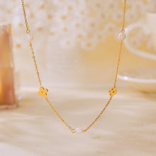 Gold freshwater pearl clover necklace displayed on a soft neutral background for boutique jewelry styling