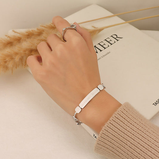 Gold geometric chain bracelet worn on the wrist with polished square accents