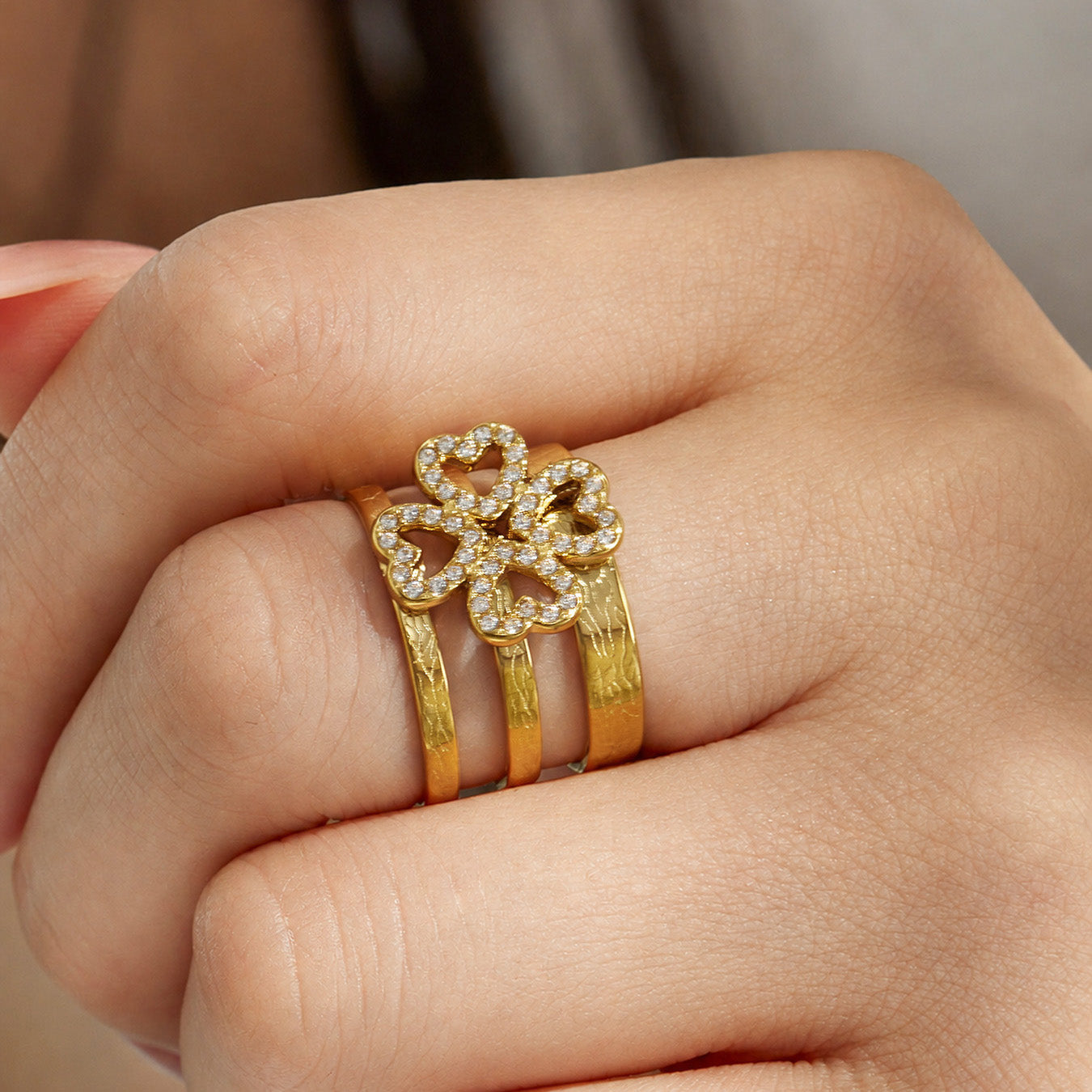 Close-up of a gold geometric CZ open ring in 316L stainless steel worn on a model finger