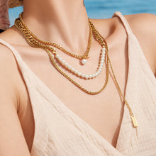 Model wearing a minimalist gold geometric layered necklace with a white outfit