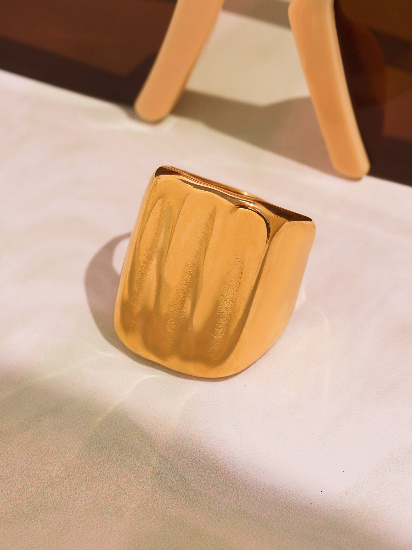 18K PVD gold geometric wide band ring product close-up with polished ridged surface