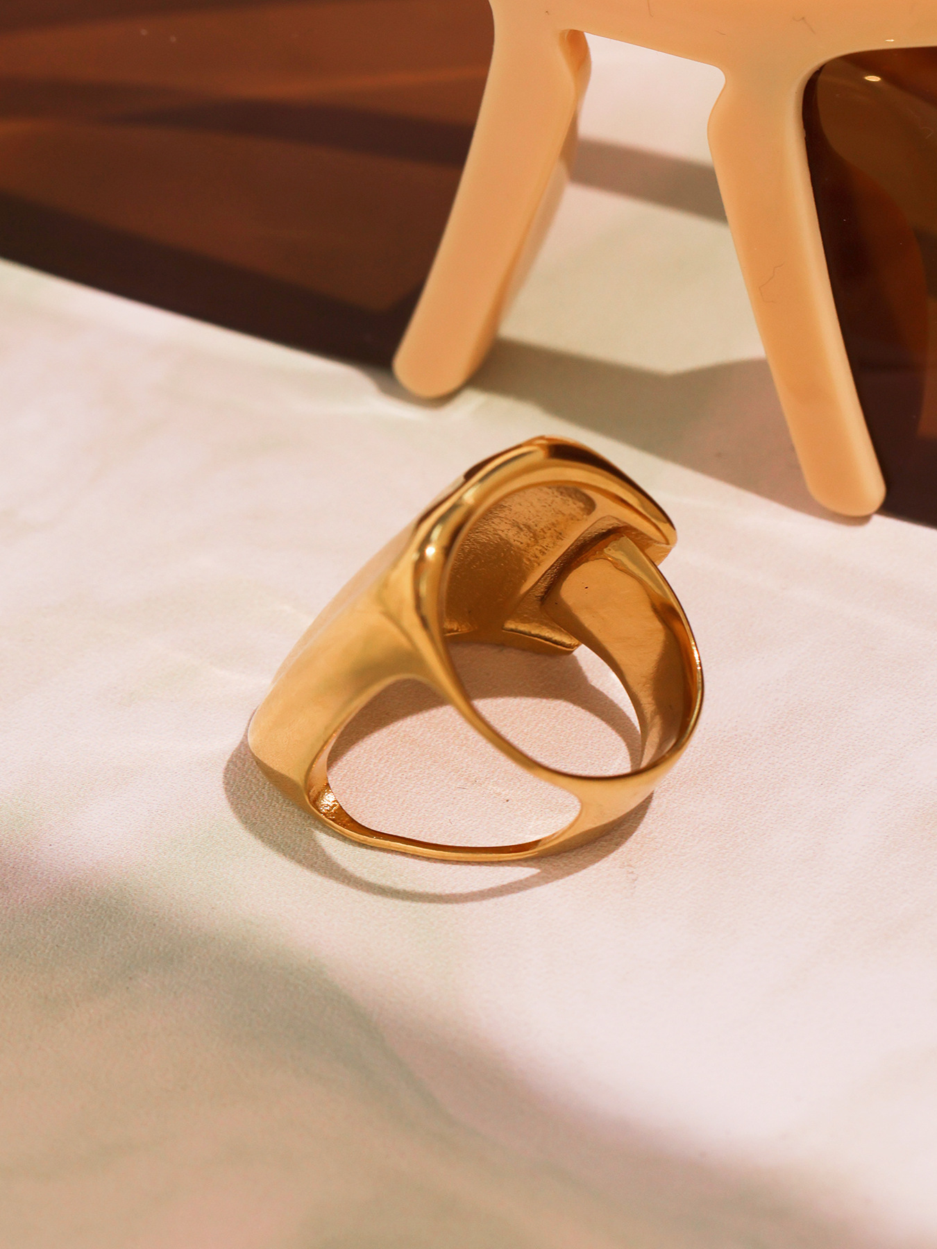 Gold geometric wide band ring side profile showing open back and bold curved shape