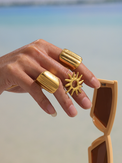 Gold geometric wide band ring close-up on hand with sunglasses for resort styling