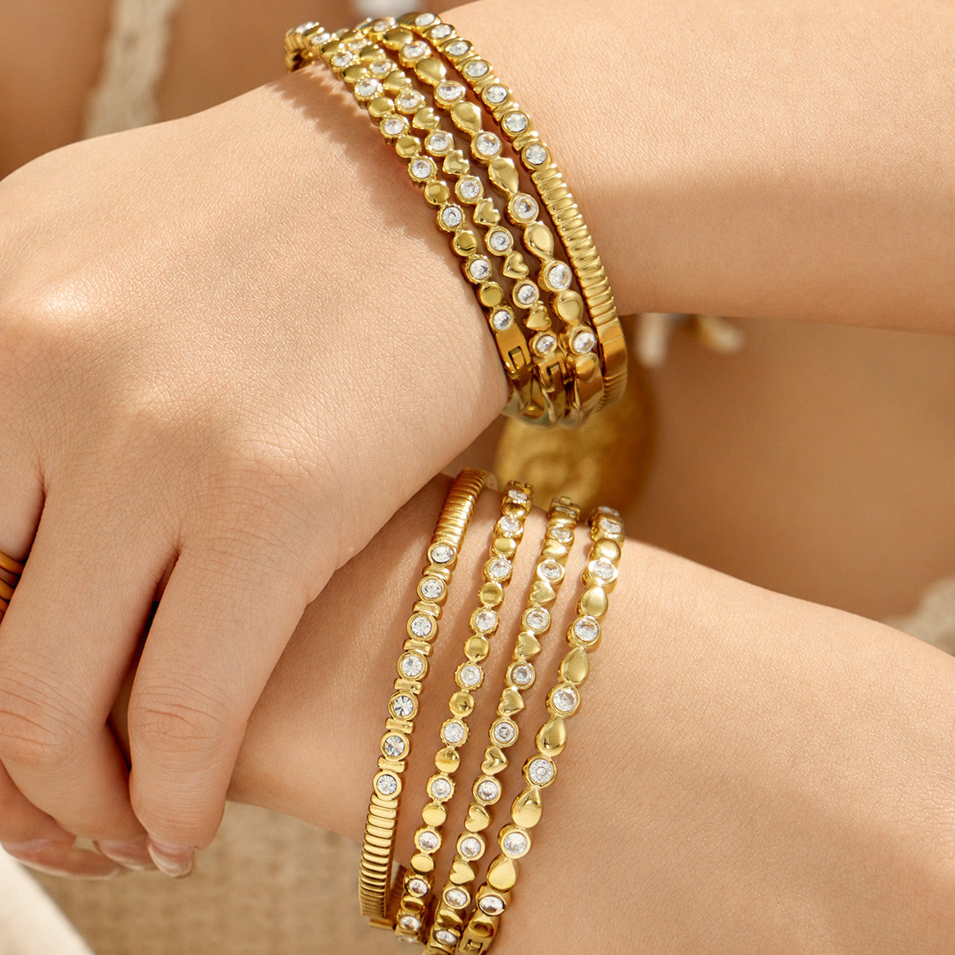Gold geometric zircon bangles stacked together on a model wrist