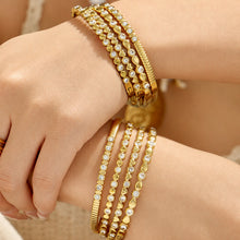 Gold geometric zircon bangles stacked together on a model wrist