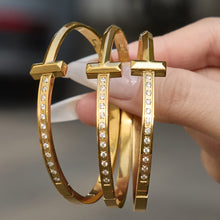 Hand holding round zircon bracelets in gold and steel tone 316L stainless steel, sparkling bracelet styles for wholesale buyers