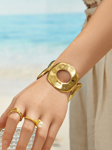Model wearing a gold hammered open cuff bracelet on the hand