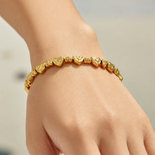 Model wearing a gold hammered heart-link bracelet on the wrist