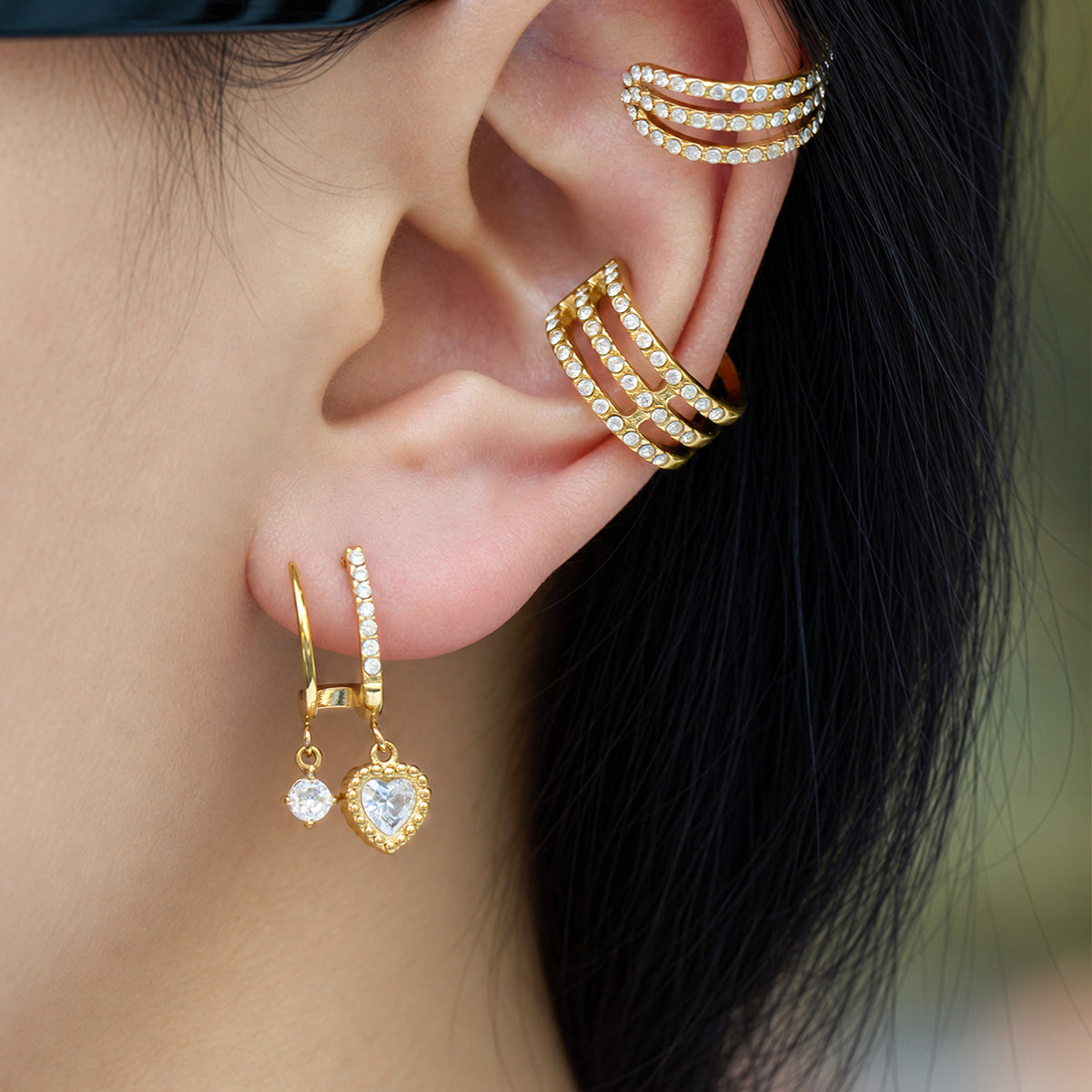 Gold-tone stainless steel heart CZ drop earrings worn on ear