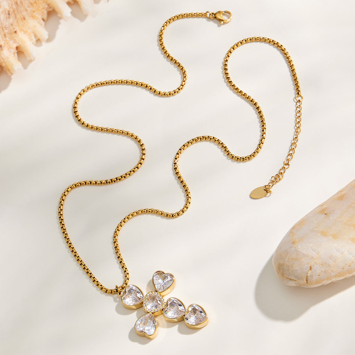 Gold heart-stone zircon cross necklace displayed flat with chain