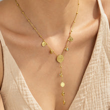 Gold-tone zircon Y necklace with coin details and heart drop worn on model