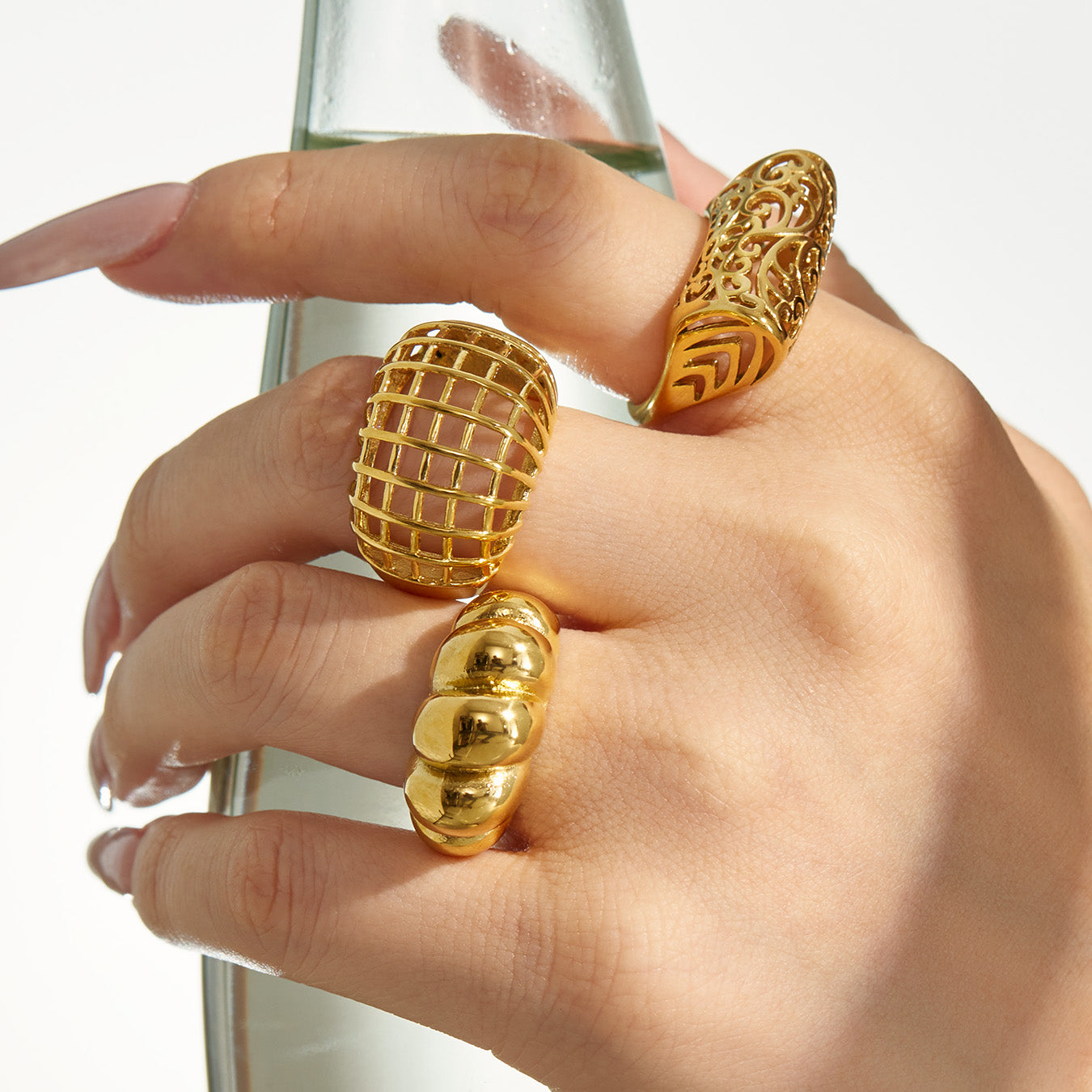 Model wearing gold tone hollow geometric 316L stainless steel statement rings