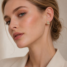 Model wearing a small gold letter stud earring