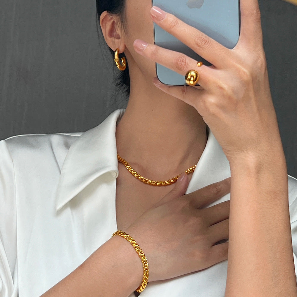 Model wearing a gold interlocking link copper necklace