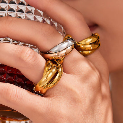 Model wearing gold interlocking statement ring with polished 18K gold finish for bold fashion jewelry styling
