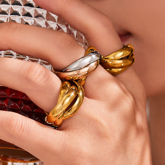 Model wearing gold interlocking statement ring with polished 18K gold finish for bold fashion jewelry styling