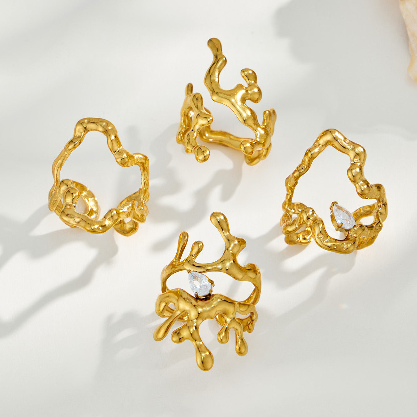 Collection of four gold 316L stainless steel irregular open rings in different sculptural styles