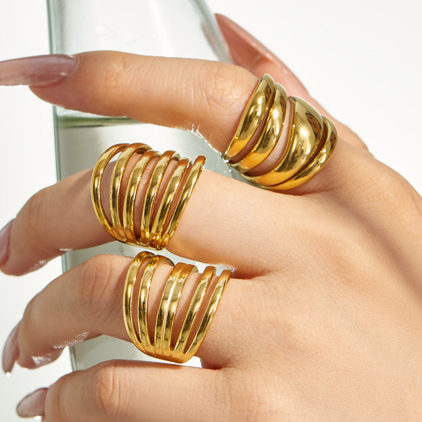 Close-up of gold tone irregular 316L stainless steel open rings styled on a model hand