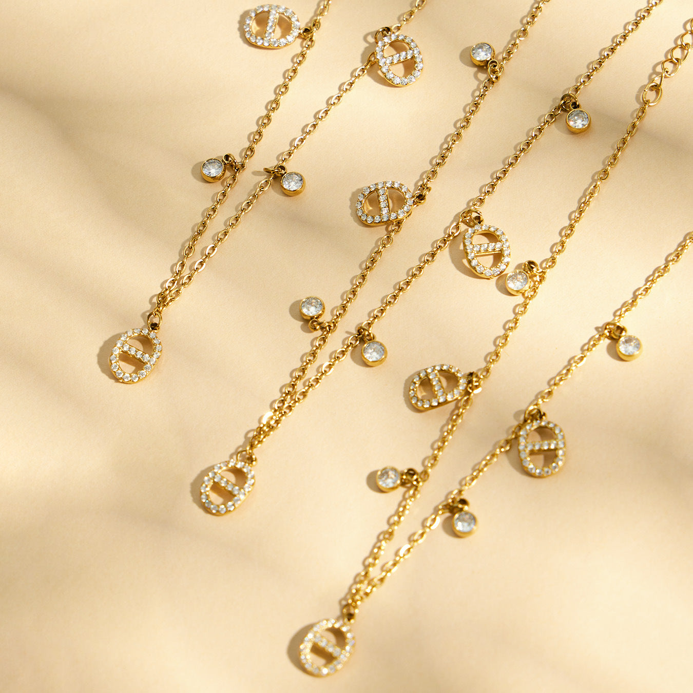 luxury gold layered necklace set with coin charms under soft shadow lighting