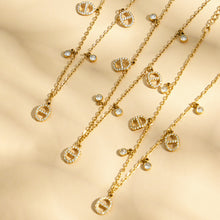 luxury gold layered necklace set with coin charms under soft shadow lighting