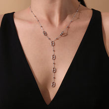 Front view of a model wearing a long gold tone stainless steel tassel necklace