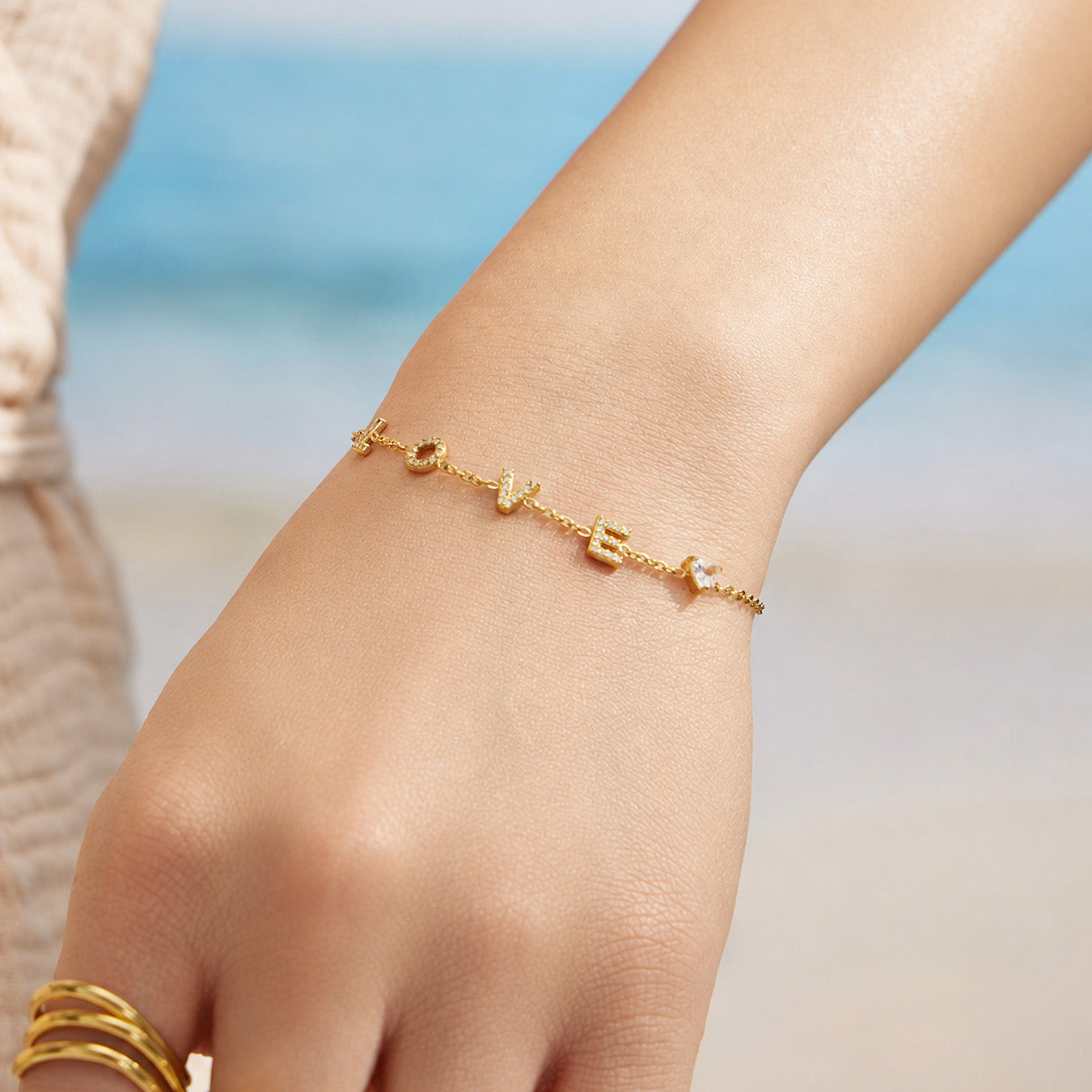 Model wearing a gold LOVE letter zircon bracelet on the wrist
