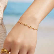 Model wearing a gold LOVE letter zircon bracelet on the wrist