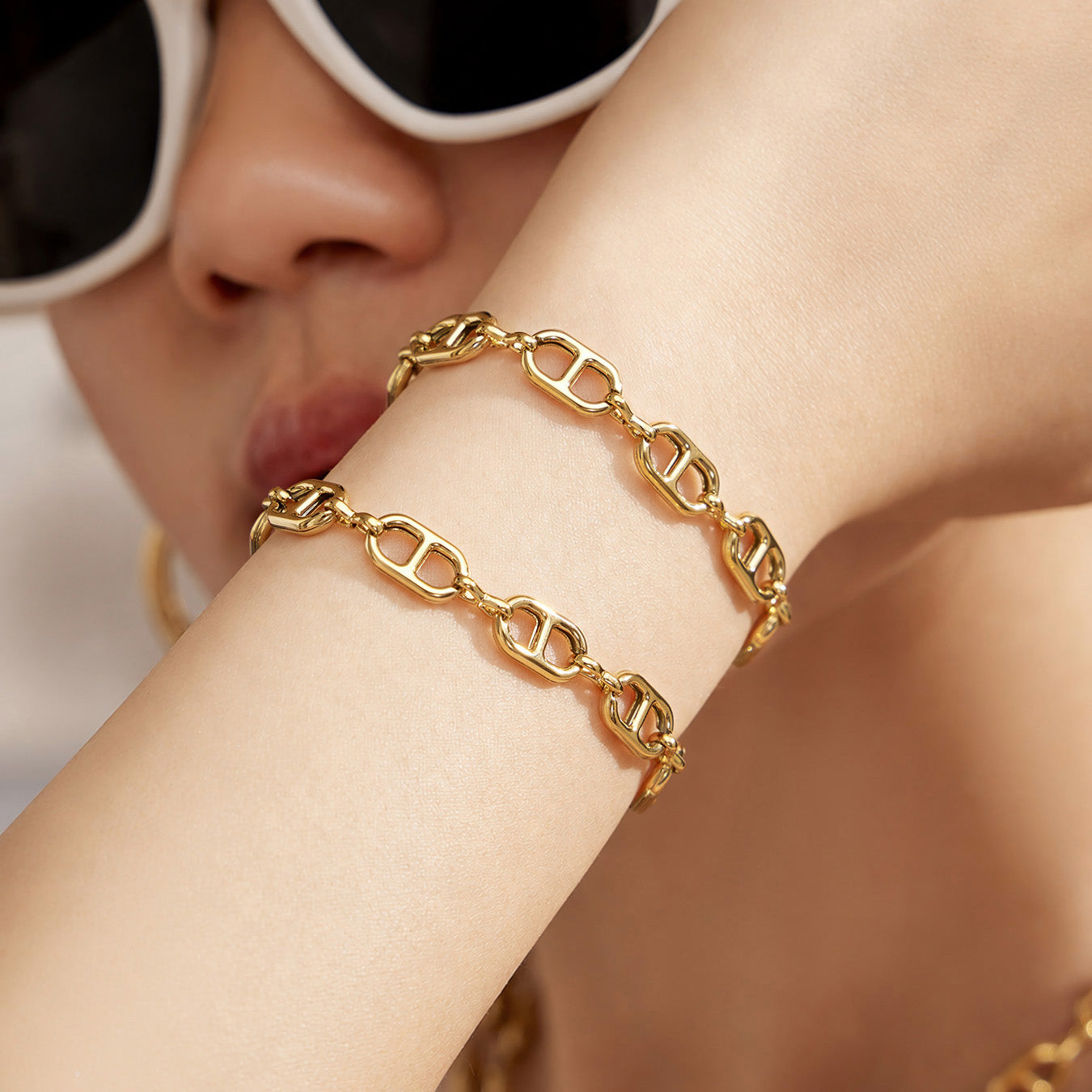 Close-up of a gold mariner link bracelet worn on the wrist