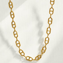 Gold mariner link necklace arranged in a clean oval flat lay