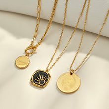 Gold round medallion, celestial and black enamel pendant necklaces displayed together