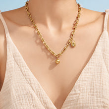 Model wearing a delicate gold minimalist pendant necklace with a white V-neck top