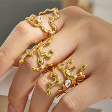 Model wearing gold molten-style 316L stainless steel statement rings with sculptural shapes