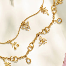 Detailed view of gold multi-charm butterfly chains with dangling zircon accents