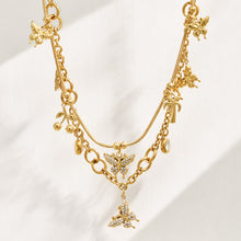 Gold multi-charm butterfly necklace displayed vertically to show the charm arrangement