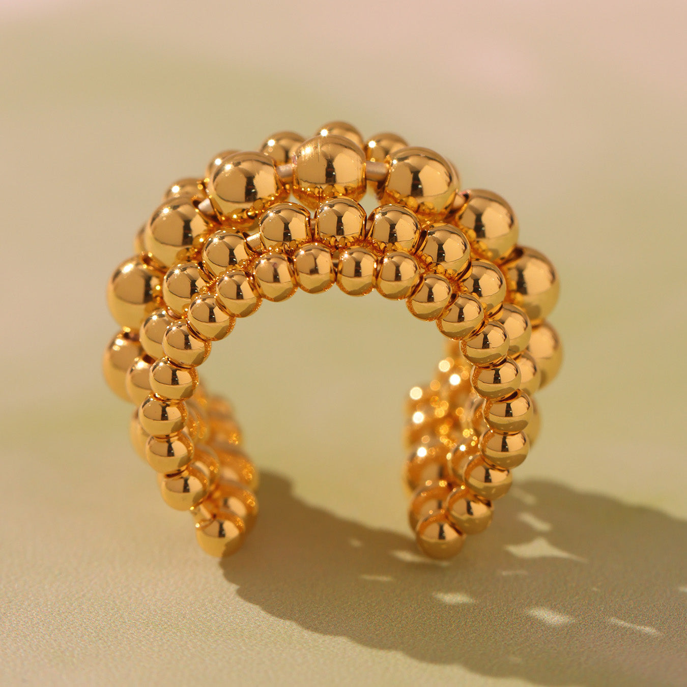 Side view of gold tone multi-row beaded stainless steel statement ring