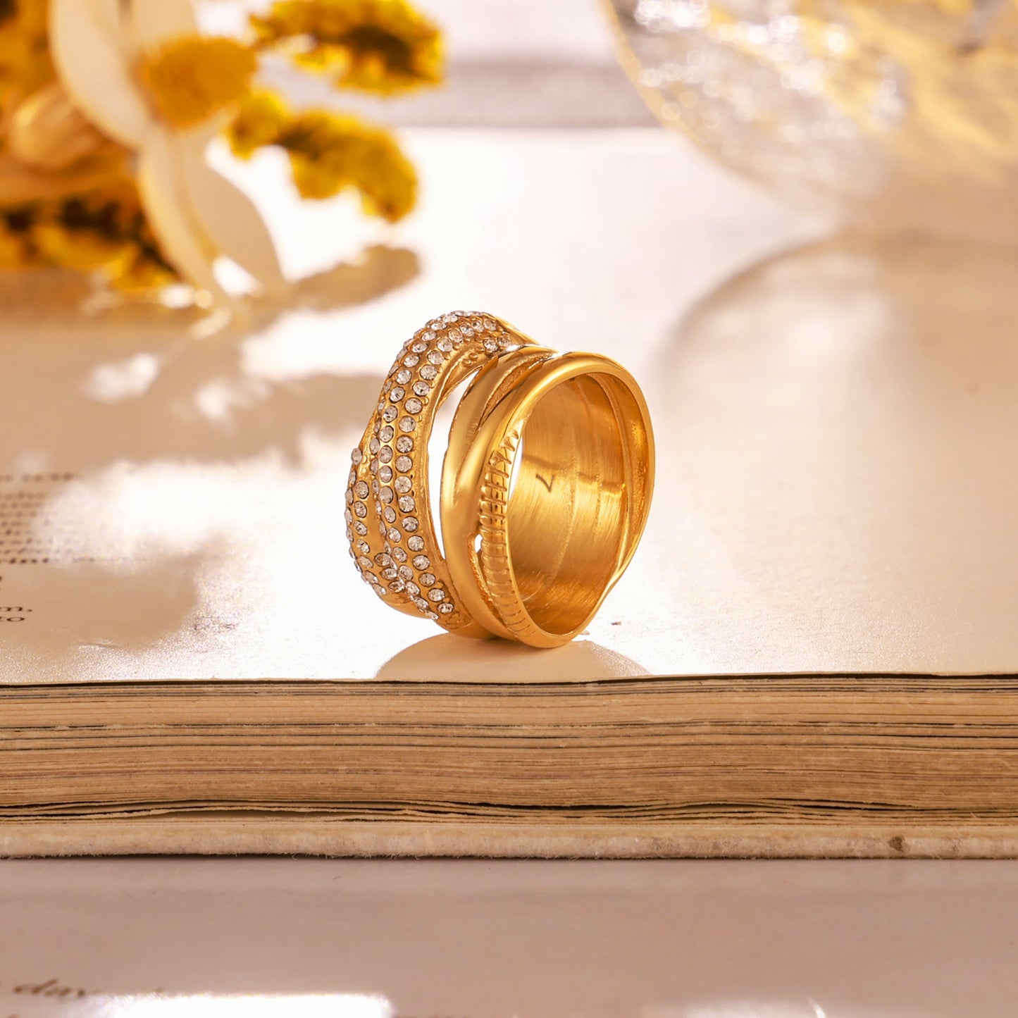 Side detail of a gold multi-row cubic zirconia ring showing the layered structure