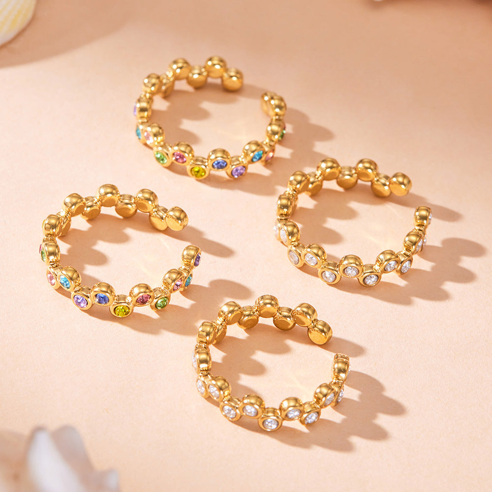 Gold multi-row cubic zirconia statement rings displayed on a neutral background