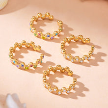 Gold multi-row cubic zirconia statement rings displayed on a neutral background