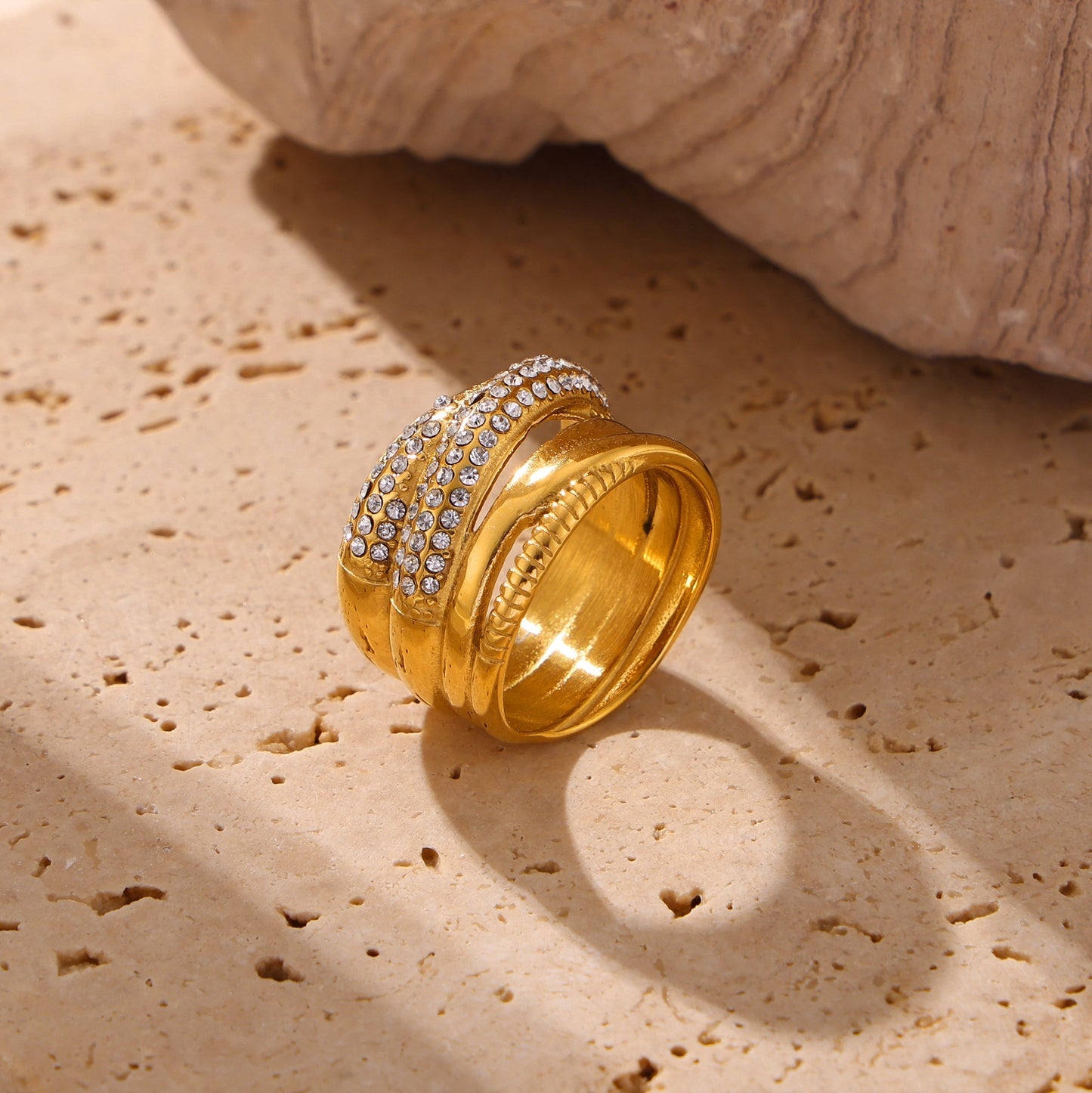 Gold multi-row statement ring with polished bands and clear cubic zirconia details