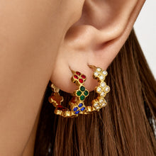 Model wearing multicolor cubic zirconia clover hoop earrings in gold