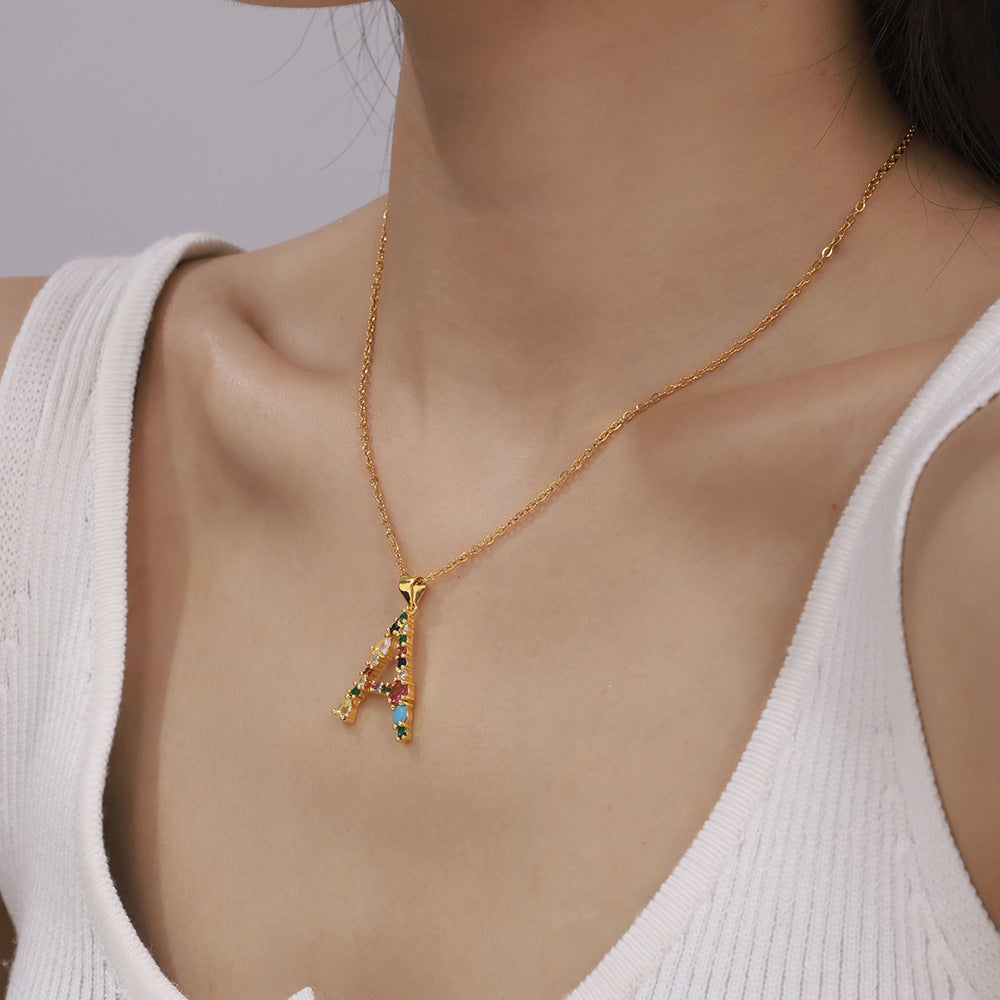 Close-up of gold multicolor zircon letter A necklace on model, colorful initial pendant necklace for personalized jewelry