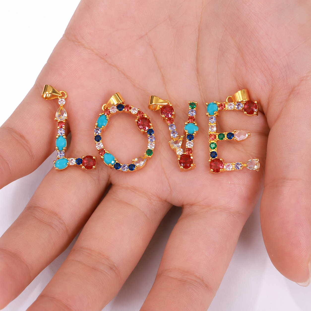 Gold multicolor zircon LOVE letter pendant charms displayed on hand, colorful initial jewelry for personalized necklaces