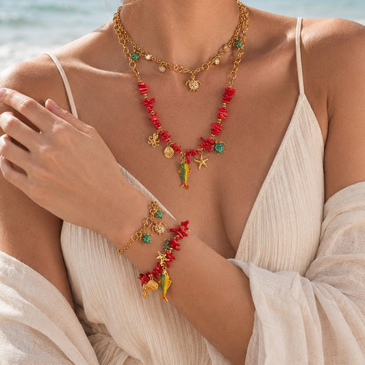 Model wearing gold ocean animal charm necklace with turtle and marine-inspired pendants for summer vacation jewelry styling