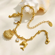 Full view of a gold ocean-inspired charm bracelet with an adjustable extender chain