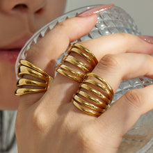 Model wearing multiple gold tone 316L stainless steel open statement ring styles