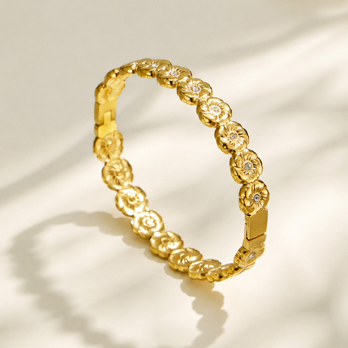 Gold openwork flower hinged bangle with clear cubic zirconia details