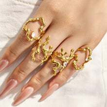 Gold organic-shaped 316L stainless steel statement rings styled together on a model hand
